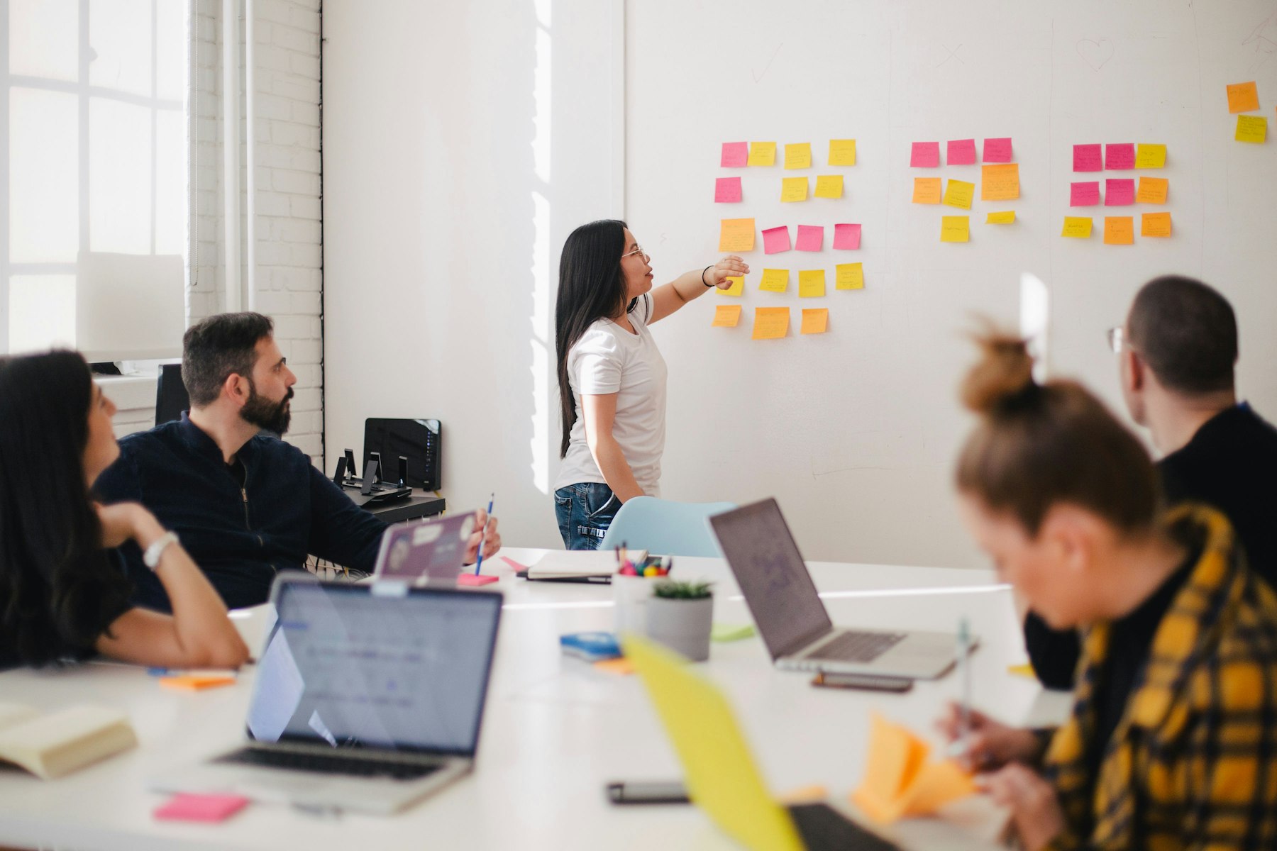 Facilitator leading a planning workshop with sticky notes on a wall