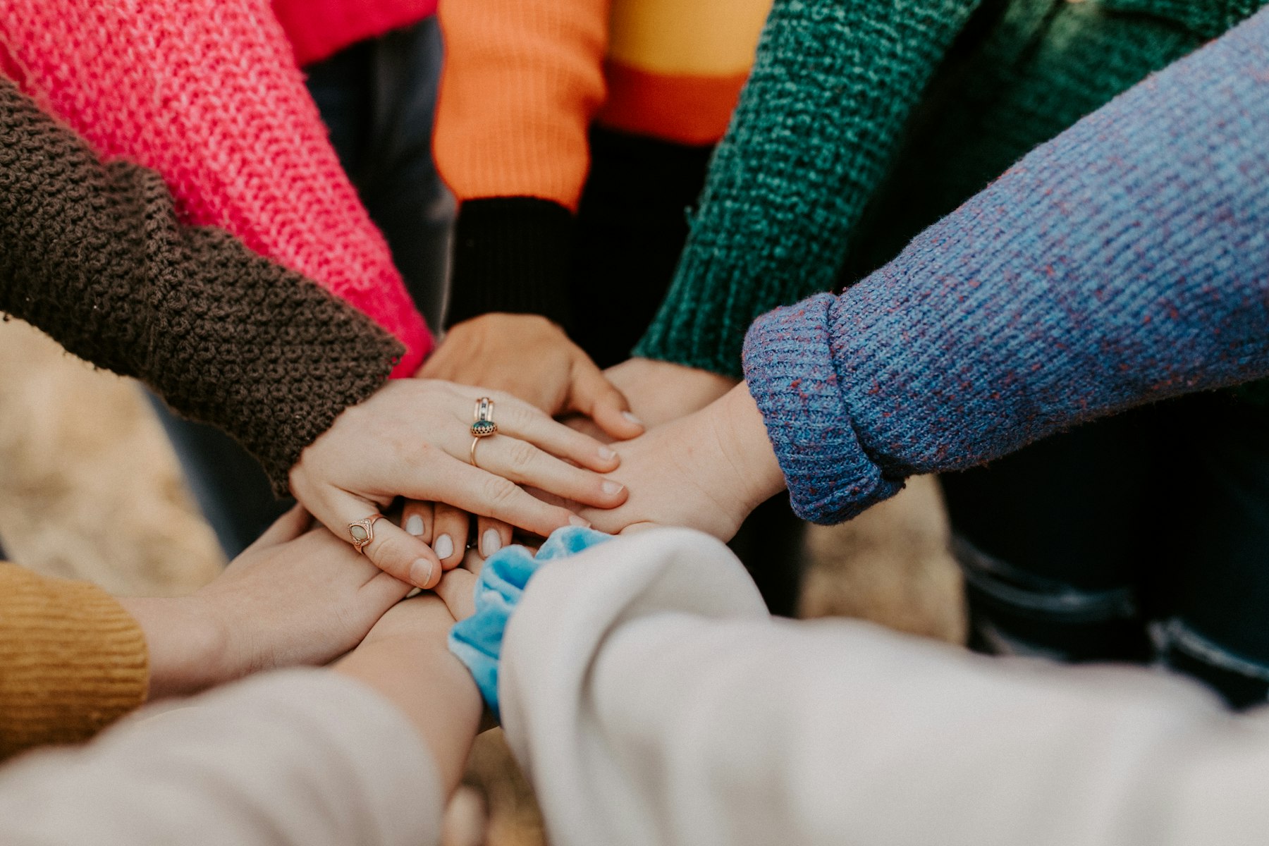 A group of people stacking their hands together in support